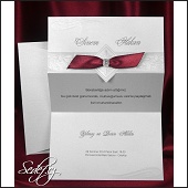 Stříbřitě bílé skládací svatební oznámení zdobené červenou stuhou s ozdobou a ražbou